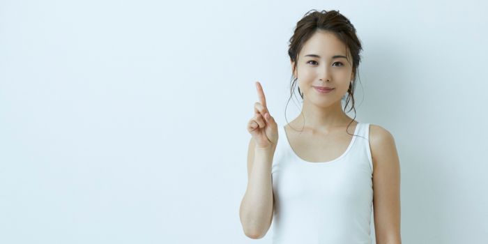 人差し指を立てる女性